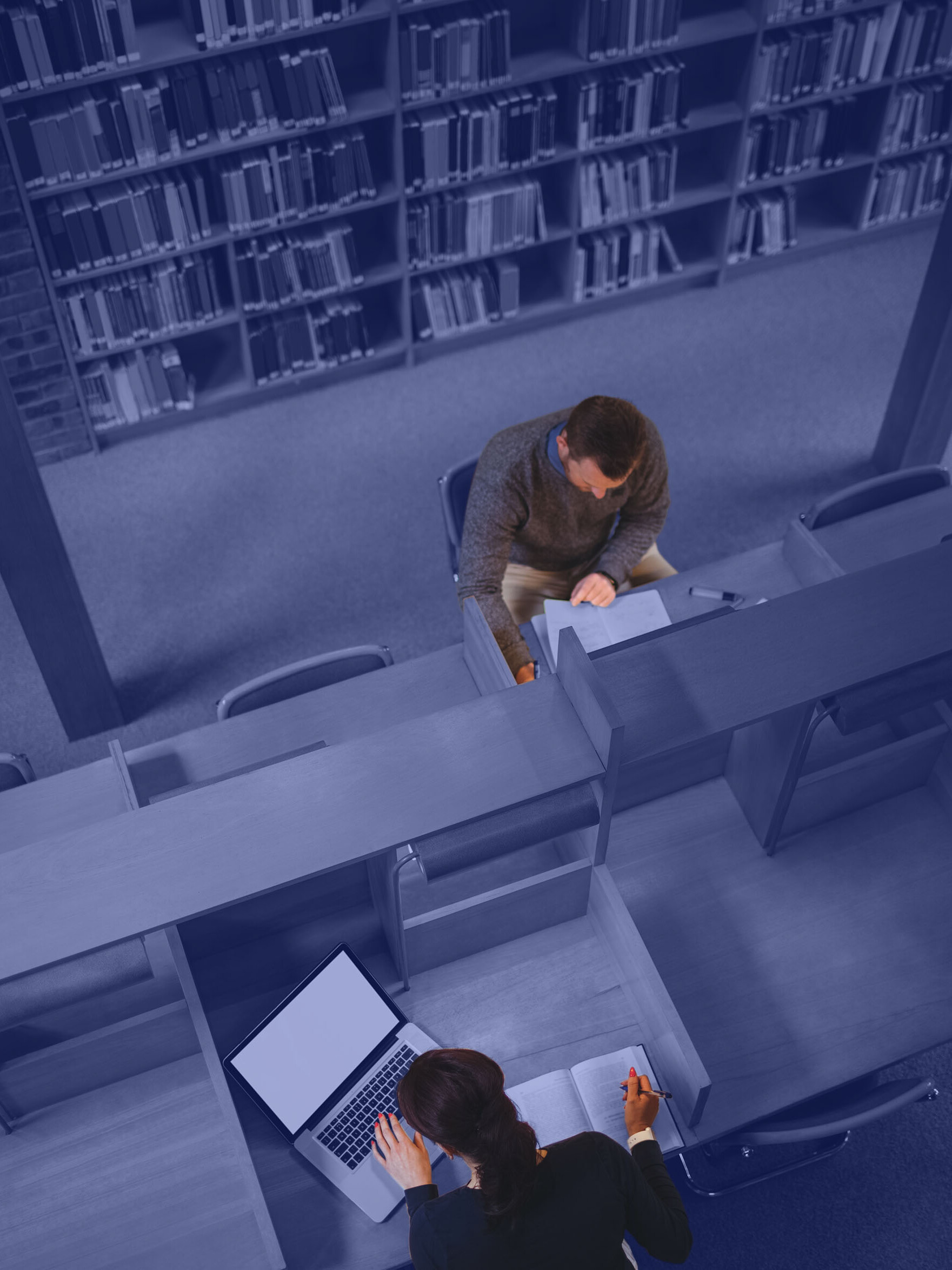 Zwei Personen lesen in einer Bibliothek